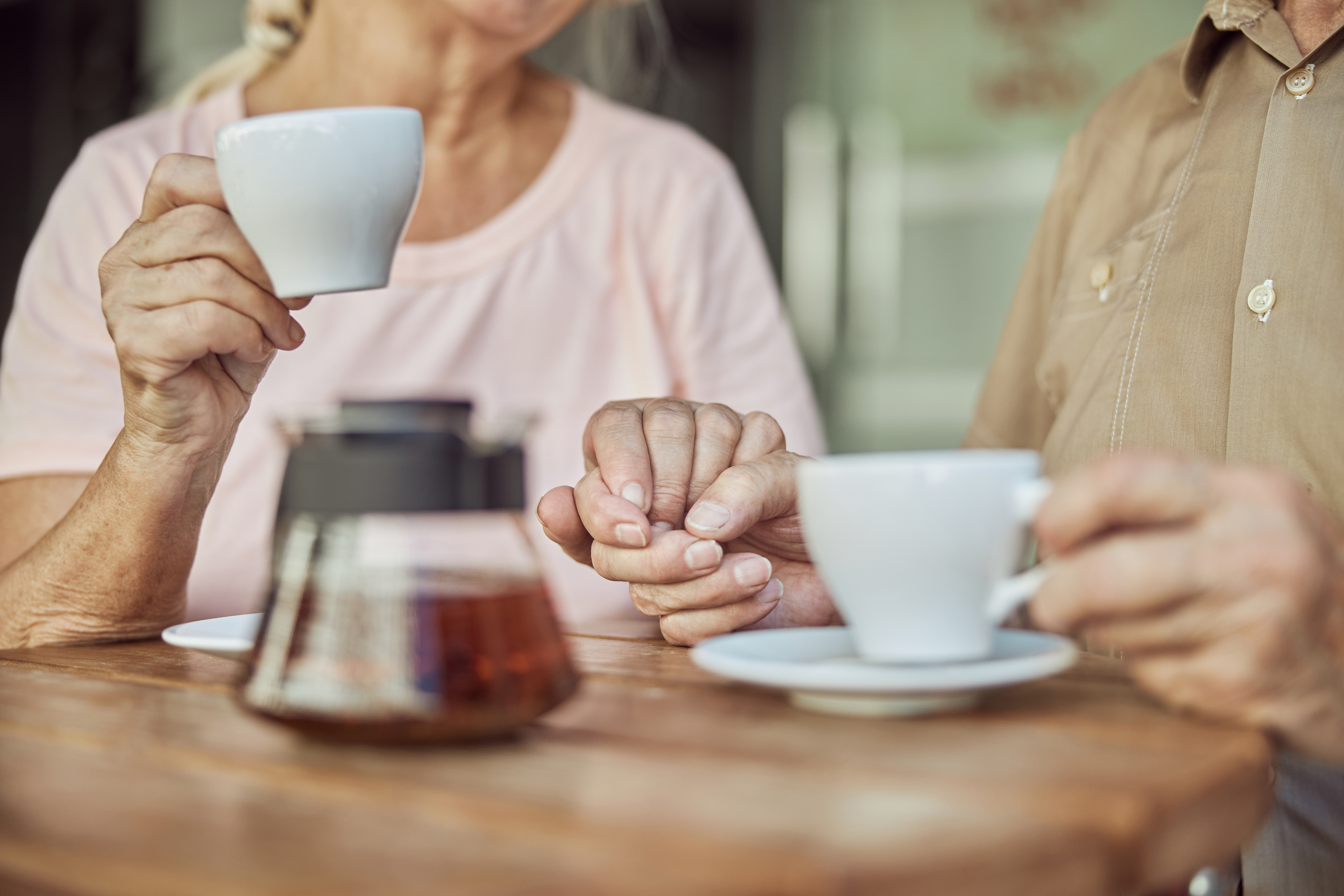 Older couple holding hands in support