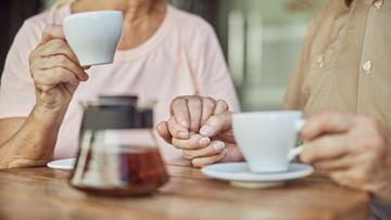 Older couple holding hands in support Older couple holding hands in support