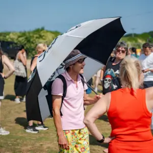 Man holding an umbrella to shade himself from the sun.