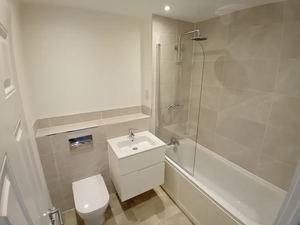 Bathroom at St James Place East Bergholt showing a sink, toilet and bath/shower.